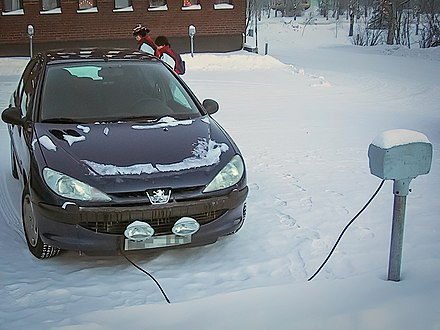A parked car plugged in to an electrical outlet to power the block heater