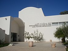 Entrée du musée du patrimoine traditionnel de Djerba avec sa façade blanche.