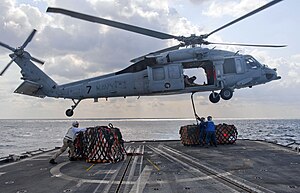 US Navy 120121-N-VY256-068 Sailors aboard the Ticonderoga-class guided-missile cruiser USS Cape St. George (CG 71) attach outgoing mail to an MH-60.jpg