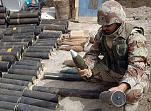 An Iraqi soldier from the 1st QRF division examines a mortar captured during clearing operations in Hayaniya, 19 April Weapons cache basra.jpg