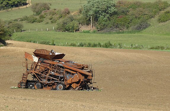 Old rusty combine harvester in a field in Lorraine (France)