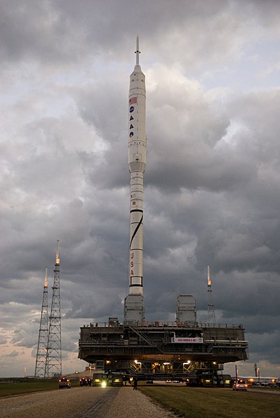 Rollout of Ares I-X at Kennedy Space Center Launch Complex 39 secured by four bolts on a mobile launcher platform.