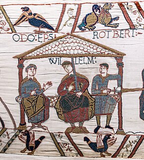 An embroiled cloth depicting three men sitting on a bench