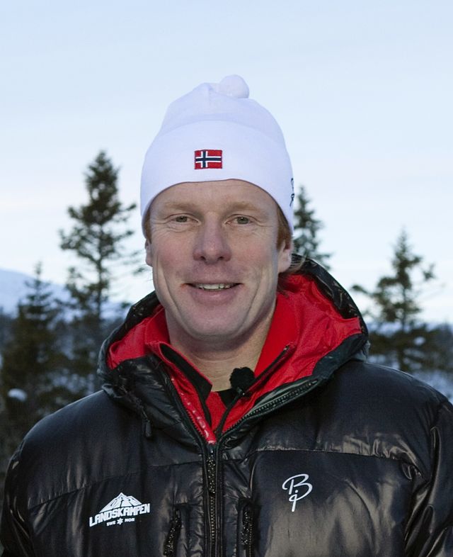 A man, standing, wearing a ski cap.