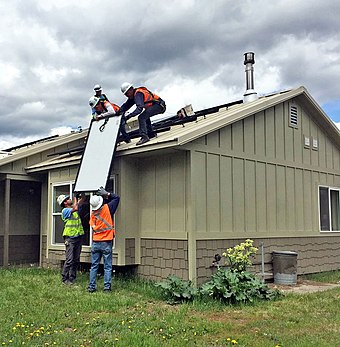 Workers install residential rooftop solar panels