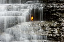 Eternal Flame Falls in New York has an eternal flame inside a small grotto behind the falls Eternal flame falls 7252.jpg