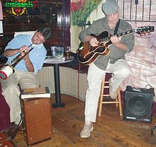A jazz guitarist with his instrument plugged into a Polytone combo guitar amp (which combines an amplifier and a speaker). FARRAR & KIRCHOFF 1, Mainstreet Jazz & Blues, Belleville, Illinois, 2004-09-03.jpg