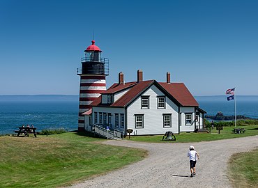 Gabriel running towards the West Quoddy Head Lighthouse, Lubec, Maine, US