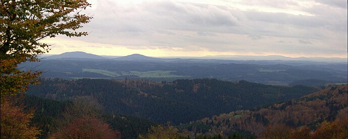 View of the Gleichberge (679 and 641 m), 24 km away. Right in the background is the High Rhön with the 928-m-high Kreuzberg 67 km away, immediately in front (centre half right) the 7-km-distant Ratscher Bergsee. In the foreground is the 621-m-high, Wachberg, 3 km away