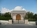 A small mausoleum surrounded by bushes