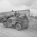 German prisoners being brought in on the bonnet of a Humber scout car, Caen, 9 July 1944.