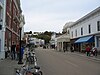 Photograph of a downtown street on Mackinac Island, lined with historic storefronts and pedestrians.