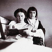 Gran Duquesa Olga lee un libro que su hermana la Gran Duquesa Anastasia (invierno de 1912-1913).