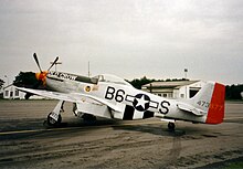 Un P-51D (au couleur du P-51B-15NA immatriculé #324324 B6+S surnommé Old Crow, de l'As Captain Clarence E. Bud Anderson Jr. ayant 16,5 victoires confirmées appartenant au 335th Fighter Squadron, 357th Fighter Group, 8th Air Force)  avec l'extension de dérive.