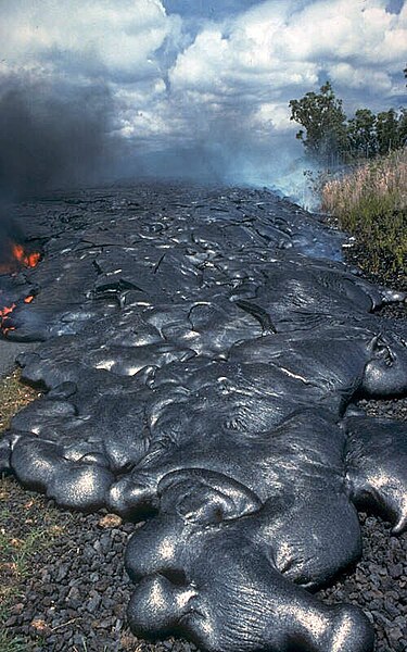 Toes of a pāhoehoe advance across a road in Kalapana on the east rift zone of Kīlauea Volcano in Hawaii, United States