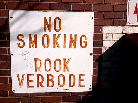 Bilingual "No Smoking" sign in English and Afrikaans at a state-owned facility