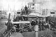 The steam tug USS Thomas Freeborn in 1861. The photo shows some of the ship's officers and men demonstrating how her late commanding officer, Commander James H. Ward, was sighting her bow gun when he was mortally wounded on 27 June 1861, during an action with Confederate forces at Mathias Point, Virginia. The gun is a 32 pounder smoothbore, of 60 hundredweight, on a "Novelty Carriage". This mounting was developed by Commander Ward before the Civil War Sighting a gun aboard USS Thomas Freeborn, 1861.jpg