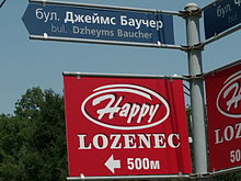 The new system is not always used properly. One of these signposts in Sofia shows the name of the district of Lozenets written according to the international scientific system of transliteration (c = ts), but in the other the name of the Irish journalist James Bourchier has been "relatinised" according to the official Bulgarian system (Dzheyms Baucher), even though the system does not apply to names that have authentic Roman spellings. Signposts in Sofia.JPG