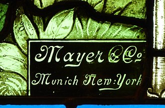 Mayer & Co. mark on stained glass window in Omaha, Nebraska. St. Stephen the Martyr (Omaha), chapel window 1, Mayer & Co mark.jpg