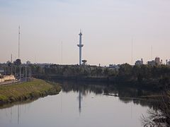 Turm mit Stadtpark von der Alsina-Brücke über den Riachuelo aus gesehen