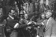 Warsaw Uprising insurgents inspect war trophies including an armband with the Wiking name Warsaw Uprising - Cyprian Odorkiewicz (1944).jpg