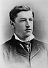 A black-and-white portrait of a young man in formal dress