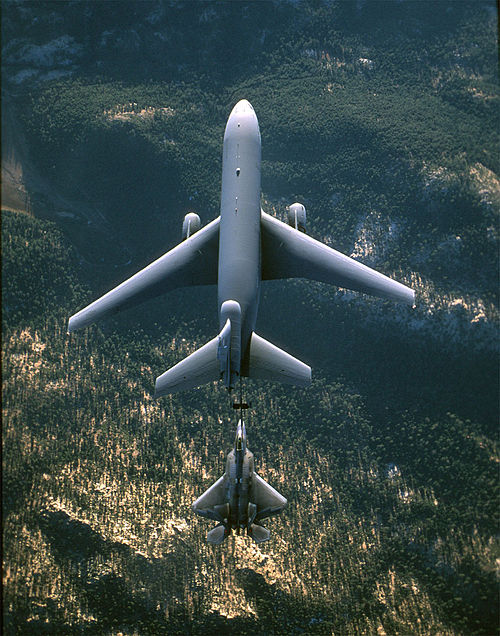 A swept wing KC-10 Extender (top) refuels a trapezoidal-wing F-22 Raptor.