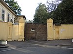 Деревянная ограда, каменные пилоны с калиткой и воротами по Нововаганьковскому переулку