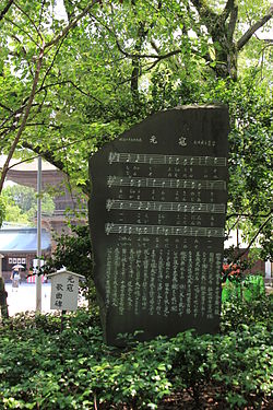 Мемориальный камень с текстом и нотами песни на территории синтоистского храма Хакодзаки