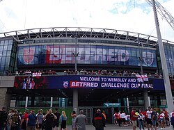 LED signage for the 2023 Challenge Cup with flags of Hull Kingston Rovers supporters draped over it.