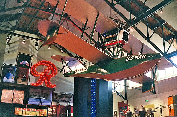 The Boeing B-1 on display in the museum's Grand Atrium, with the Rainier Brewing Company logo sign behind.