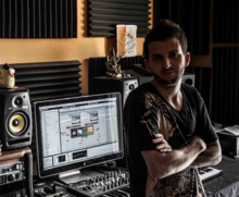 Bruce Gil in a mastering studio (a near-field studio monitor can be seen on the left. Bruce Gil in studio.png