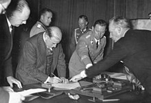 Photo of the signing of the Munich Agreement with Schmundt in the background