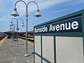 Standard platform-mounted Helvetica sign along the Woodlawn-bound platform.