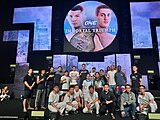 The harmony group photo of the physician and nursing team from City International Hospital with One Championship pro-fighters on the stage.