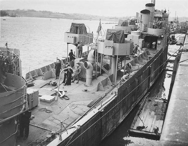 HMS Campbeltown being converted for the raid. There are twin lines of armour plate down each side of the ship and the Oerlikon mountings. Two of her f