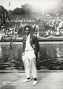Photographie noir et blanc d'un homme en costume devant une piscine