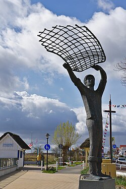 Statue of a fisherman throwing a net in Haffkrug, Germany