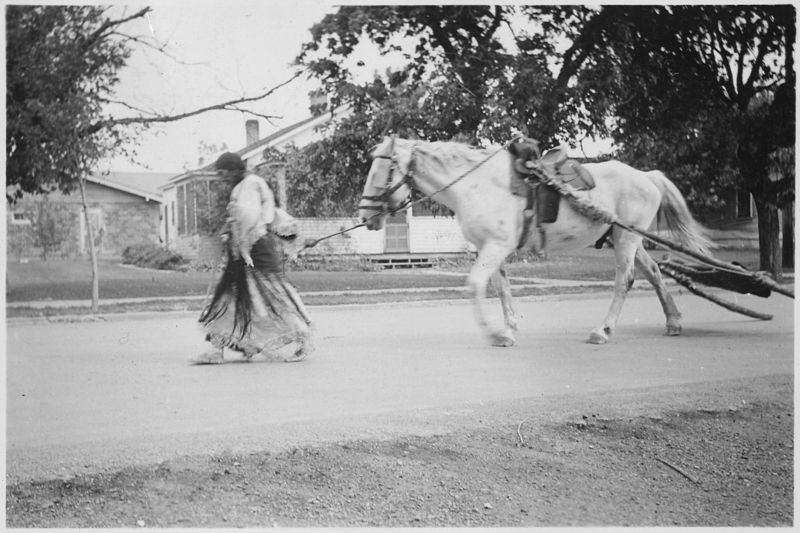 File:Indian women leading horse pulling travois through the streets - NARA - 285237.jpg