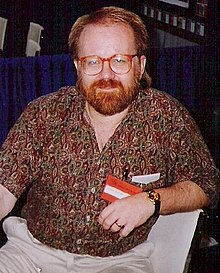 Photo d'un homme à la barbe rousse et portant des lunettes