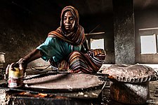 Sudanese woman making the traditional baking called "Kisra, by c:User:Alfateh2005 (Mohamed Elfatih Hamadien), from Sudan