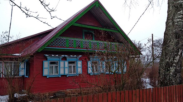 The red house with carved wooden horses on windows