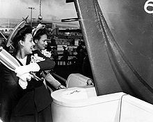 Lena Horne, sponsor of George Washington Carver, prepares to swing the champagne bottle at the launching of the Liberty ship, 7 May 1943. The woman at Horne's left may be Beatrice Turner, the matron-of-honor of the launching, and the first African American female welder hired by the Richmond Shipyards Lena Horne launching SS George Washington Carver.jpg