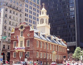 Colonial style red brick building with a white cupola in an urban setting