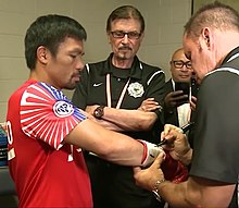 Pacquiao gets his gloves inspected by an official. Pacquiao in locker room.jpg