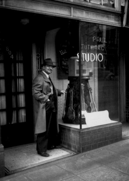 Paul Tutmarc, inventor of the modern bass guitar, outside his music store in Seattle, Washington