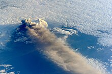 Photographie de mai 2013 prise depuis la station spatiale internationale du mont Pavlof en éruption masqué par son panache volcanique et accolé au Pavlof Sister.
