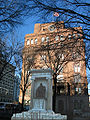 The statue of Peter Cooper, on the background of the school he founded, called "Cooper Union" in Manhattan, NYC