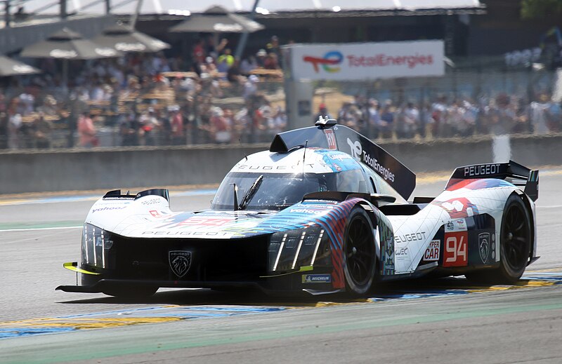 File:Peugeot 9X8 - Nico Muller, Loic Duvall & Gustavo Menezes exits Dunlop Chicane at the 2023 Le Mans (53365770237).jpg