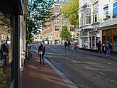 Street view in the quite Utrechtsestraat with some people walking & talking; free photo Amsterdam, Fons Heijnsbroek 12-10-2021